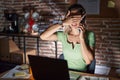 Young beautiful woman working at the office at night speaking on the phone smiling and laughing with hand on face covering eyes Royalty Free Stock Photo