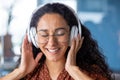 Young beautiful woman working in the office at the workplace, close-up hispanic woman in headphones singing along and