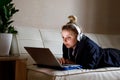 Young beautiful woman works for a computer from a home with a laptop as a freelancer Royalty Free Stock Photo