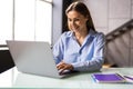 Young woman works for a computer from a home with a laptop on a white desk as a freelancer Royalty Free Stock Photo