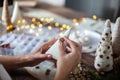 Young beautiful woman wrapping a foam cone with string yarn and crafting Christmas Tree