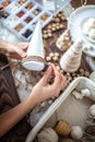 Young beautiful woman wrapping a foam cone with string yarn and crafting Christmas Tree