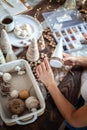 Young beautiful woman wrapping a foam cone with string yarn and crafting Christmas Tree