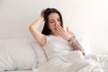 Young beautiful woman yawning on bed in morning Royalty Free Stock Photo