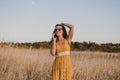 Young beautiful woman in yellow dress talking with mobile phone. Countryside. Outdoors. Travel concept. Sunset Royalty Free Stock Photo