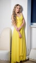 Beautiful woman in a yellow evening dress. Beauty portrait of a model with a hairstyle Royalty Free Stock Photo