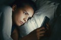 Young beautiful womanl in bed using mobile phone late at night at dark bedroom, internet addiction concept Royalty Free Stock Photo