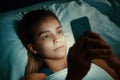 Young beautiful womanl in bed using mobile phone late at night at dark bedroom, internet addiction concept Royalty Free Stock Photo