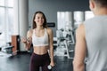 Young beautiful woman doing exercises with dumbbell in gym. Glad smiling girl is enjoying with her training process. She is