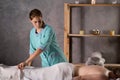 Young beautiful woman on massage table in beauty spa. Masseuse getting for work with patient. Royalty Free Stock Photo