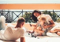 Young beautiful woman smiling to the boy who playing chess with his father. Royalty Free Stock Photo