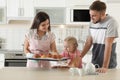 Young beautiful woman treating her family with freshly oven baked buns