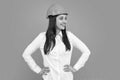 Young beautiful worker woman in helmet isolated on gray background