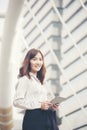 Young beautiful working woman holding smart tablet in the city