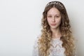 Young beautiful young girl with long curly hair, no makeup with a clean face with a wreath on his head portrait in the studio on a Royalty Free Stock Photo