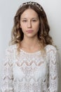 Young beautiful young girl with long curly hair, no makeup with a clean face with a wreath on his head portrait in the studio on a Royalty Free Stock Photo