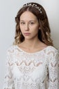 Young beautiful young girl with long curly hair, no makeup with a clean face with a wreath on his head portrait in the studio on a Royalty Free Stock Photo