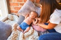 Young beautifull woman and her baby on the floor over blanket at home