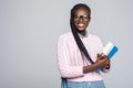 Young beauty african woman casual daily lifestyle student holding notebooks smiling isolated on grey Royalty Free Stock Photo