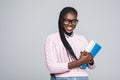 Young beauty african woman casual daily lifestyle student holding notebooks smiling isolated on grey Royalty Free Stock Photo