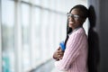 Young beauty afro american girl student in glasses holding notebooks in modern University hall