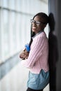 Young beauty afro american girl student in glasses holding notebooks in modern University hall