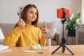 Young beauty blogger shooting vlog at home