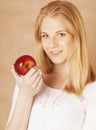 Young beauty blond teenage girl eating chocolate smiling, choice between sweet and apple Royalty Free Stock Photo