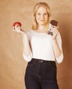 young beauty blond teenage girl eating chocolate smiling, choice between sweet and apple Royalty Free Stock Photo