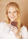 Young beauty blond teenage girl eating chocolate smiling Royalty Free Stock Photo