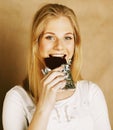 Young beauty blond teenage girl eating chocolate smiling Royalty Free Stock Photo