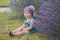 Young beauty child girl posing in central park meadow close to lavander bush wearing jeans dress and violet purple bandana with my