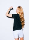 Young beauty fitness blonde woman showing her muscles, her back to the camera, long hair and smiling. Indoor. Warm color. Royalty Free Stock Photo