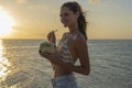 Young beauty girl drinking coconut at tropical beach near sea water at paradise island at sunset. Summer concept. Holiday travel Royalty Free Stock Photo