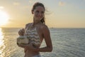 Young beauty girl drinking coconut at tropical beach near sea water at paradise island at sunset. Summer concept. Holiday travel Royalty Free Stock Photo