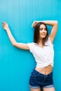 Young beauty girl posing against blue colorfull wall