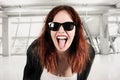 Young beauty hipster woman screaming and showing tongue, funny face with sunglasses Royalty Free Stock Photo