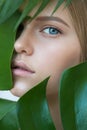Young beauty smiling blonde model with natural make up and green leaf Royalty Free Stock Photo