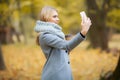 Young Beauty woman listening music in autumn forest Royalty Free Stock Photo