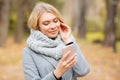 Young Beauty woman listening music in autumn forest Royalty Free Stock Photo