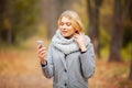 Young Beauty woman listening music in autumn forest Royalty Free Stock Photo