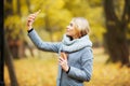 Young Beauty woman listening music in autumn forest Royalty Free Stock Photo