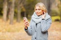 Young Beauty woman listening music in autumn forest Royalty Free Stock Photo