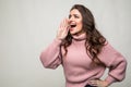 Young beauty woman shout and scream using her hands as tube, studio shoot isolated on white background