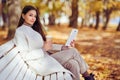 Young beauty woman sitting with a cup of coffee on a bench in the fall park Royalty Free Stock Photo