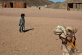 A young Bedouin boy with his camel in the desert