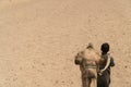 A young Bedouin boy with his camel during a trek in the desert