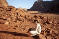 A young bedouin man wearing long white jubba thobe dress and sandals