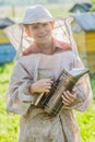 Young beekeeper checking hives on bee yard