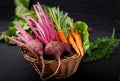 Young beetroot and carrots with a tops in a basket